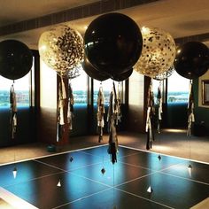 some balloons are hanging from the ceiling in a room with blue tile flooring and windows