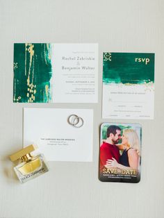 the wedding stationery is laid out on top of the table, including an engagement ring