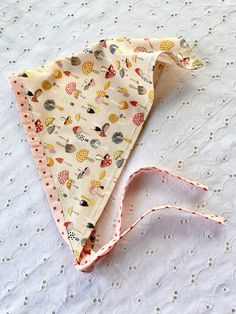 a white table topped with a pink and yellow cloth covered in different types of fabric