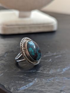 This is a gorgeous example of a handmade oval,  large turquoise Native American Ring. Size 3.5, it features stunning colors with dark turquoise against deep coppery accents. Measures: 7/8 " long Condition: this vintage ring shows signs of use and age. Please look at the pictures for details. It has surface scratches. The band itself is slightly uneven. Thank you for looking! Feel free to reach me with questions and visit my shop for additional art, books, holiday decor items, jewelry, or other unique gifts and home finds ♥ Vintage Chrysocolla Turquoise Ring, Southwestern Turquoise Ring With Oval Cabochon, Southwestern Turquoise Oval Cabochon Ring, Southwestern Oval Cabochon Turquoise Ring, Vintage Turquoise Ring With Large Oval Stone, Southwestern Oval Turquoise Ring With Natural Stones, Southwestern Style Oval Turquoise Rings, Southwestern Adjustable Oval Turquoise Ring, Artisan Turquoise Oval Cabochon Ring