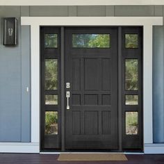 a front door with two lights on each side and an entry mat in the middle