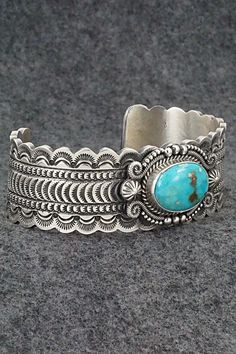 This stunning Kingman turquoise and sterling silver bracelet featuring a scalloped edge cuff was made by Navajo silversmith Michael Calladitto. The inside is signed M&R Calladitto and stamped Sterling.Size: 5 3/4" (will fit up to a 7 1/8" wrist)Gap: 1 3/8"Width: 1"Free shipping on all orders! We ship with USPS and always include tracking. All orders ship within a day of payment.Returns are accepted up to 30 days after you receive your order. Just send us a message. Our shop offers cash back or s Turquoise Stamped Bangle, Etched Turquoise Sterling Silver Jewelry, Elegant Engraved Turquoise Sterling Silver Bracelet, Elegant Turquoise Engraved Sterling Silver Bracelet, Western Style Bangle Jewelry Gift, Western Style Bangle Jewelry As Gift, Western Style Bangle As Gift, Artisan Turquoise Engraved Bracelets, Southwestern Style Etched Turquoise Jewelry