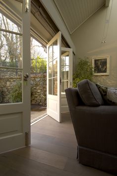 a living room filled with furniture next to a door and window covered in glass doors