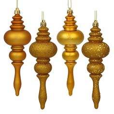 four gold christmas ornaments hanging from strings