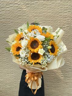 a person holding a bouquet of sunflowers