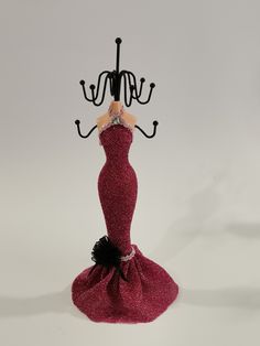 a red dress with black trim and a chandelier in the shape of a woman's head