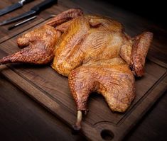 a whole turkey on a cutting board with knifes