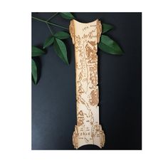 a wooden clock sitting on top of a table next to a green leafy plant