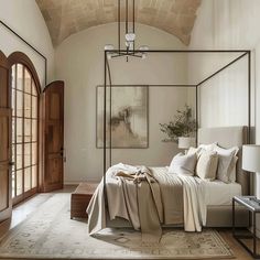 a bedroom with a canopy bed in the middle and an arched doorway leading to another room