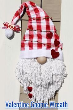 a red and white gnome door hanger with hearts on it