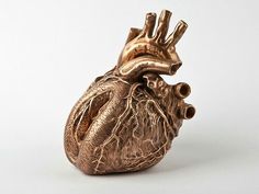 a bronze heart sculpture sitting on top of a white table