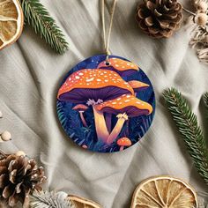 an ornament with two mushrooms on it surrounded by pine cones and orange slices