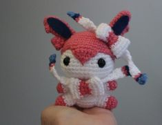 a small crocheted animal is being held up