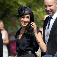 the woman is talking on her cell phone while standing next to two men in suits