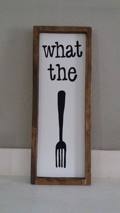 a sign that says what the fork is in front of a wall with a wooden frame