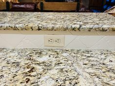 a granite counter top with two outlets in the middle