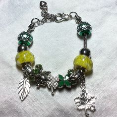 Snake Chain Euro Beaded Bracelet Is 6 1/2 Inch +2 1/2-Inch Extender Chain. Has Two Yellow Glass Beads (14.3 Mm, 15.0 Mm) Two Green Acrylic Beads With Silver, Texturing, Design (12.5 Mm, 12.1 Mm, Two Metal Rondelles, With Green Rhinestones, Green Flower, Shamrock, And Leaf Charms, Two Leaf Dangles (3/4” Each). All Euro Beaded Jewelry Items Have Interchangeable Beads. You Can Arrange Them Anyway You Like Or Totally Change The Look. Just Unscrew One Side To Add Or Remove Beads. Green Accessories, Womens Jewelry, Green Flower, Leaf Charms, Acrylic Beads, Green Flowers, Snake Chain, Earings Piercings, Womens Jewelry Bracelets