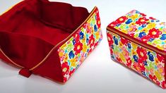 two colorful bags sitting next to each other on a white surface with red zippers