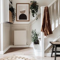 a living room filled with furniture next to a stair case covered in potted plants