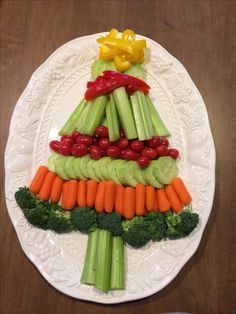 a white plate topped with vegetables and veggies on top of a wooden table