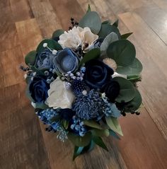 a blue and white bouquet sitting on top of a wooden floor