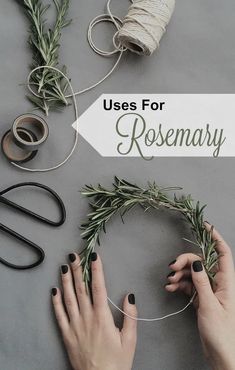 two hands with black nails are making a wreath made out of rosemary and twine