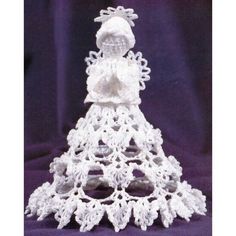 a white crocheted christmas tree with snowflakes on it's sides