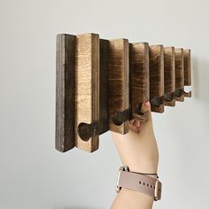 a hand holding a wooden musical instrument with keys