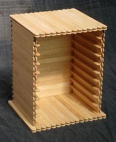 a small wooden structure made out of plywood planks on a black cloth background