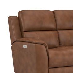 a brown leather reclining sofa with the arm rest down and headrests up