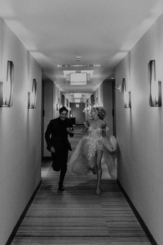 a man and woman walking down a hallway