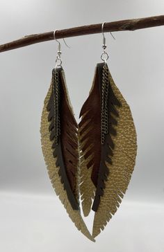 These are fun boho leather earrings. Long earrings in a rustic style. Handmade in Los Angeles, USA. Please note that this is a handmade item made from leather scraps and may have slight imperfections or color variations. Hang them or store them horizontally. Keep them away from water, cosmetics and hair products. DO NOT immerse them in water.  For home care, you can use a product such as Tandy Leather Conditioner. Bohemian Hand-tooled Leather Earrings, Bohemian Leather Dangle Earrings, Handmade Rustic Leather Earrings, Handmade Leather Earrings For Festivals, Handmade Brown Faux Leather Earrings, Festival Handmade Leather Earrings, Rustic Brown Leather Earrings, Earthy Brown Earrings For Festivals, Brown Hand Tooled Earrings For Festival