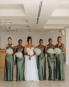 a group of women standing next to each other holding bouquets in front of them