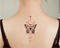 the back of a woman's neck with a butterfly and moon tattoo on it