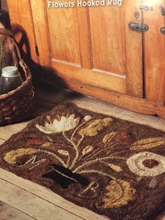 a brown rug sitting on top of a wooden floor next to a basket filled with flowers