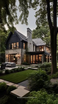 a large house with lots of windows and trees in the front yard, surrounded by greenery