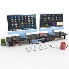 two computer monitors sitting on top of a desk next to a keyboard, mouse and coffee cup