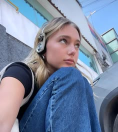 a woman sitting on the ground with headphones in her ears