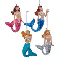 three mermaid ornaments are hanging from strings