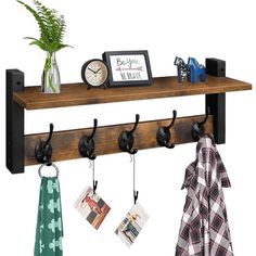 a wooden shelf with three hooks and two pictures hanging on the wall next to it