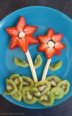 fruit arranged in the shape of flowers on a plate with kiwis and strawberries