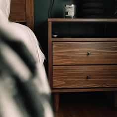 a bedroom with a bed, night stand and two nightstands next to each other