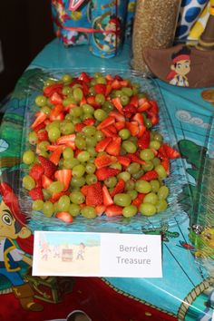 grapes and strawberries are arranged on a plastic tray at a children's birthday party