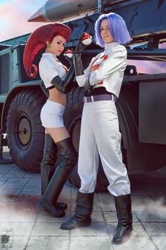 two women dressed in costumes standing next to each other near a large truck with missiles on it