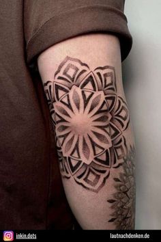 a woman's arm with a tattoo on it and an intricate flower in the center