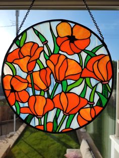 a stained glass window with orange flowers on it