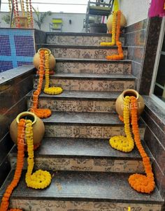 the steps are decorated with orange and yellow garlands on each step, along with two vases filled with flowers