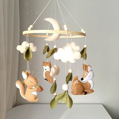 a baby crib mobile with two stuffed animals hanging from it's sides and the moon in the background