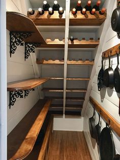 an empty pantry with pots and pans hanging on the wall next to shelves filled with cooking utensils