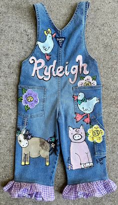 Custom painted Birthday overalls for a toddler girl painted in poppin colors of yellow, bright pink and blue and orange with cow, horse, pig, rooster and chicks. Super sweet denim with a pink painted barn on the bib.  Perfect for Barnyard Birthday parties, but you can also have them customized for every day wear and not add the birthday theme.  I have added bows and flowers to the animals, and pink ruffles sewn to the hem. Oh so sweet.  I also have pictured overalls in a primary color scheme as well as long overalls. so many ways to customize my designs just for your little one.  I used upcycled, recycled clothing in excellent used condition, and sometimes new, it really depends on what I can find throughout the year. I prefer to work with name brand denim like oshkosh, old navy, arizona j Barn Party Outfit, Girly Farm Birthday Party, Farm Birthday Outfit, Birthday Overalls, Pink Farm Birthday, Painted Overalls, Cowboy Themed Birthday Party, Long Overalls, Barnyard Birthday Party